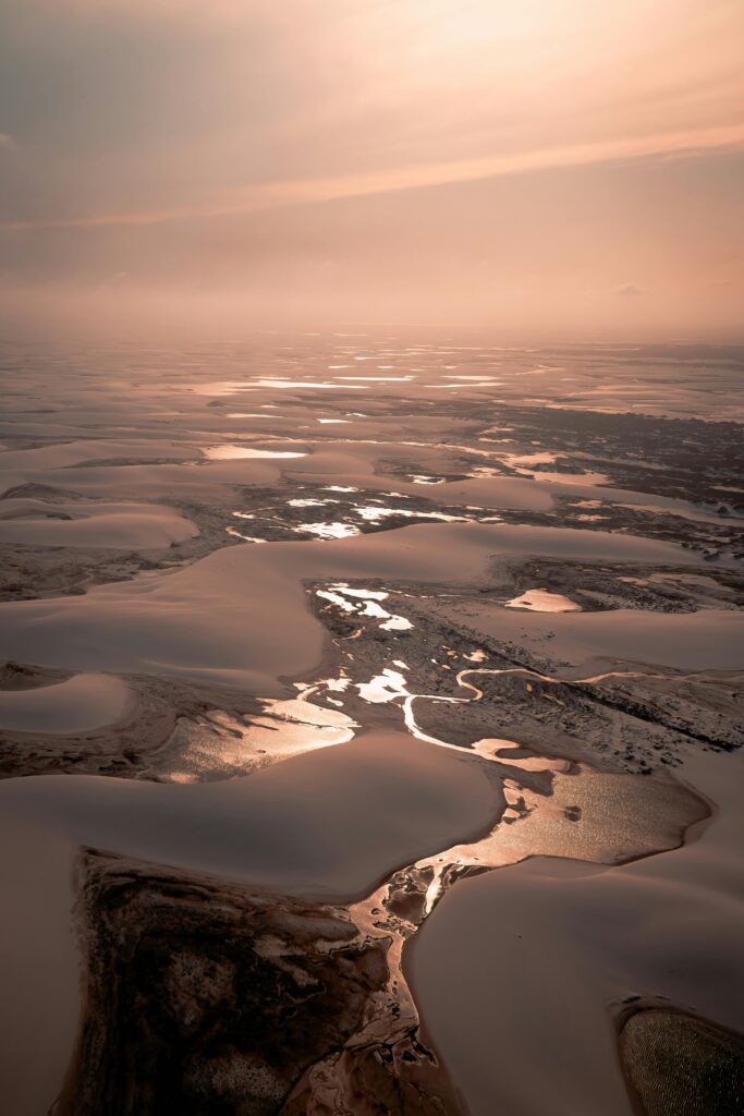 Stunning aerial panorama of frozen lakes and dunes at dusk in Atins, Brazil.