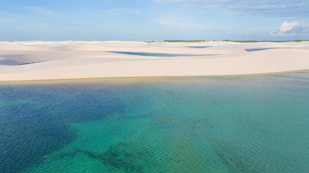 pexels-photo-27688575-27688575 Discover the breathtaking sand dunes and turquoise lagoon of Lençóis Maranhenses National Park in Brazil.