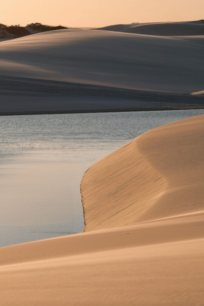 pexels-photo-33259370-33259370 A serene sunset view over the sand dunes and lagoon in Lençóis Maranhenses National Park, Brazil.