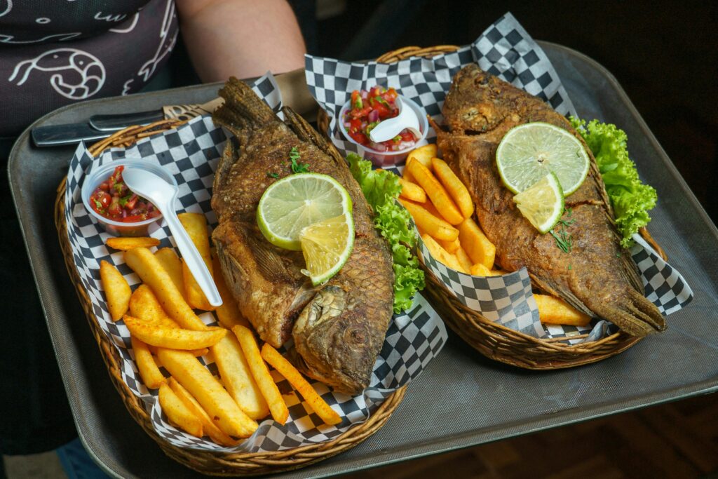 Delicious fried fish served with lime, fries, and salsa. Perfect for a seafood feast.