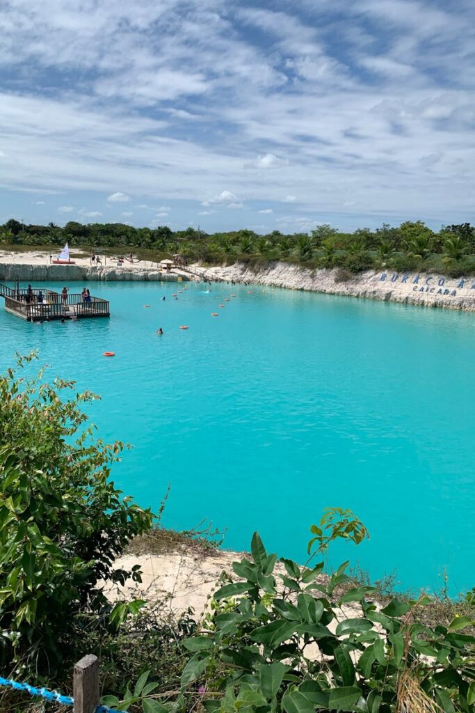 Clear blue waters of Buraco Azul lagoon in Brazil with a dock and scenic surroundings.