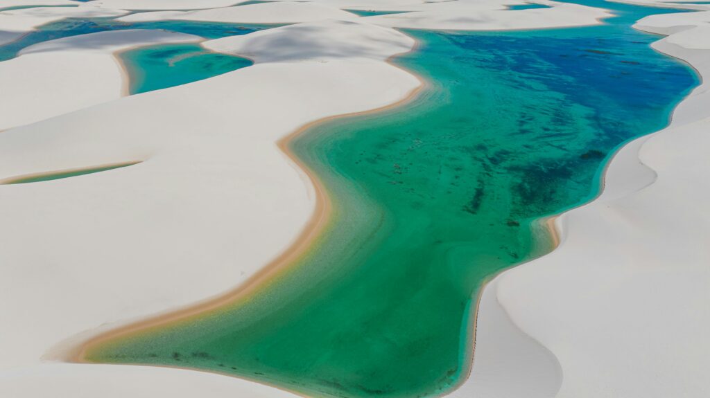 Aerial shot of Lençóis Maranhenses' vibrant lagoons and dunes in Brazil.