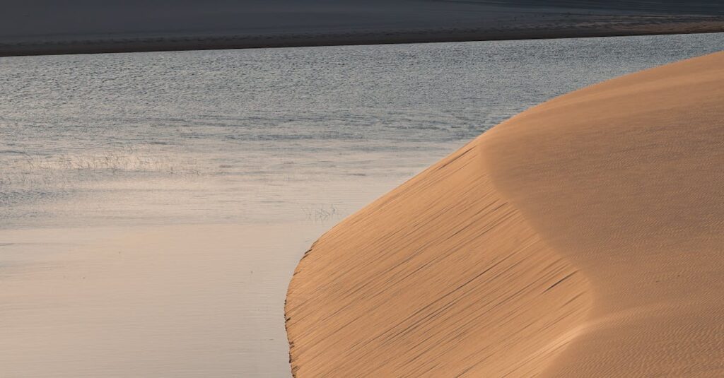 A serene sunset view over the sand dunes and lagoon in Lençóis Maranhenses National Park, Brazil.