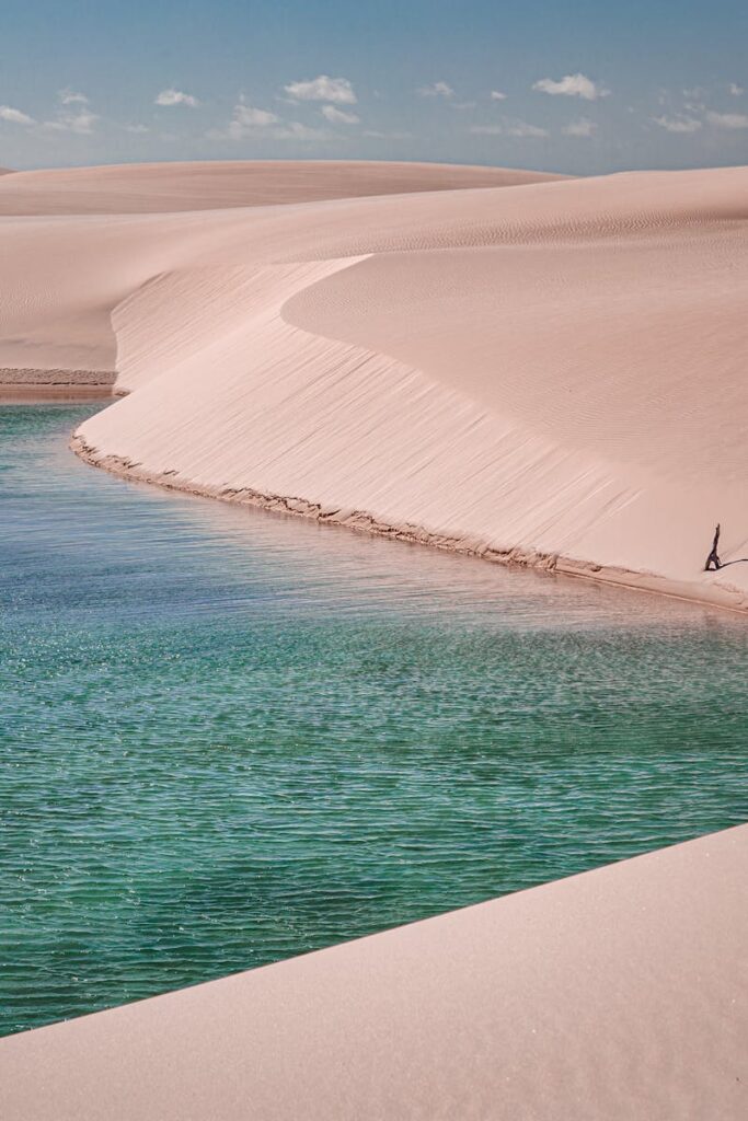 Experience the stunning beauty of Lençóis Maranhenses with pristine sand dunes and a turquoise lagoon.
